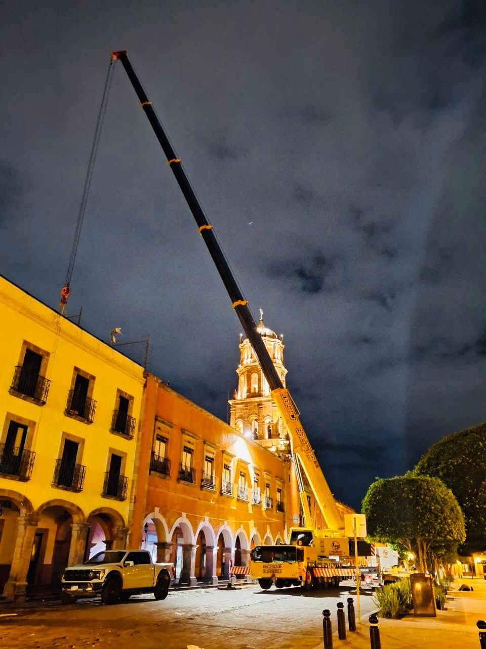 Grúa Liebherr LTM 1350 en maniobra nocturna en el centro histórico